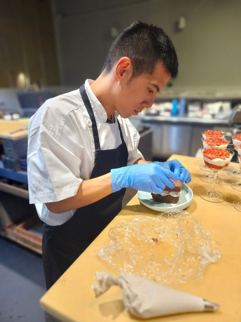 Chef Victor Kwan plating a dessert in the kitchen